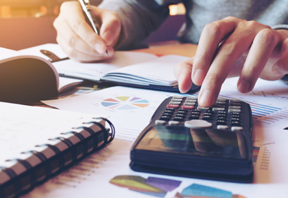 Hands using calculator to assess a capital improvement project