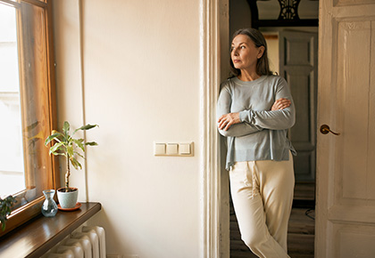 Woman looking out a window, evicting a tenant in British Columbia