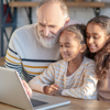 grandad checking laptop with grandkids