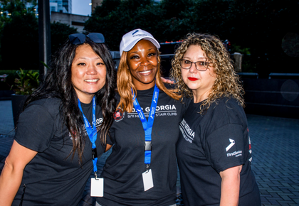 Three women wearing matching team shirts