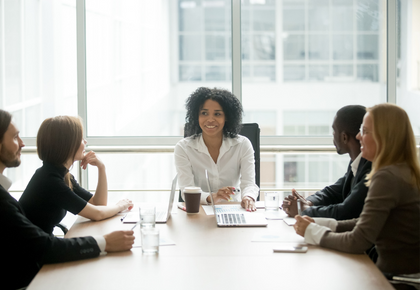 People sitting around a conference table with laptops