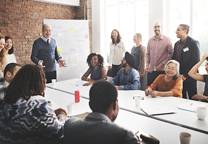 Group of people around a presenter while in a meeting - FirstService Residential