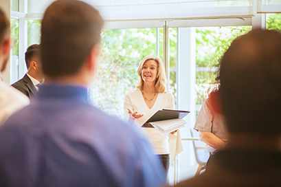 Blonde female community association manager holding team meeting